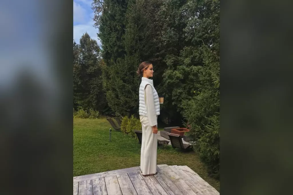 Валентина Алексеева в белом костюме на деревянном настиле в саду