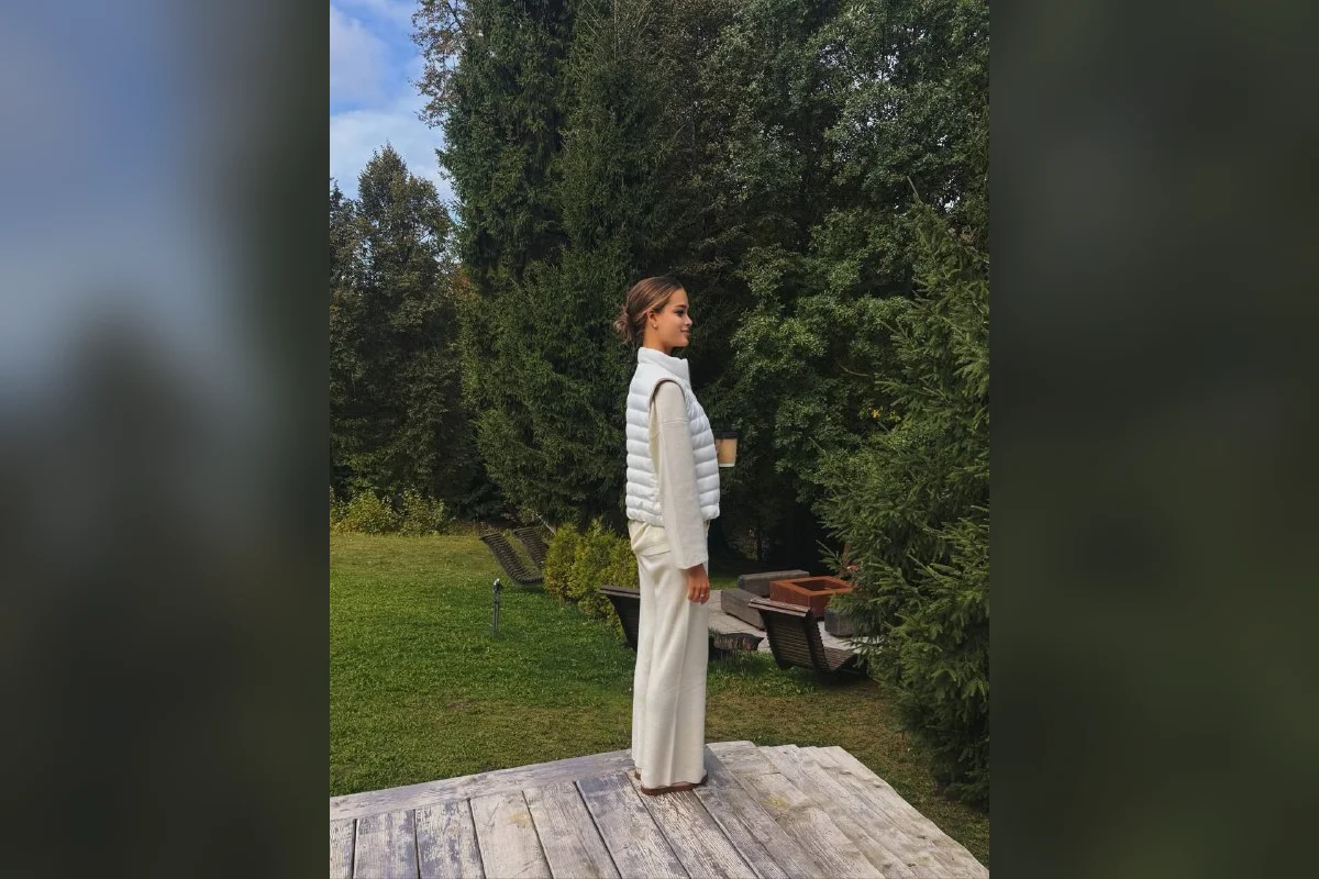 Валентина Алексеева в белом костюме на деревянном настиле в саду